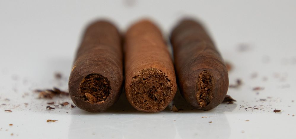 Cigars cut in all three styles - the punch is on the left, straight cut in the middle, and the v-cut is on the right.